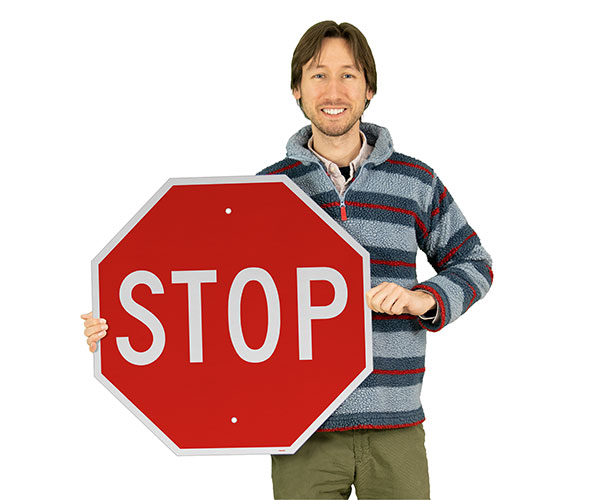 A man holding an MUTCD Compliant Stop Sign