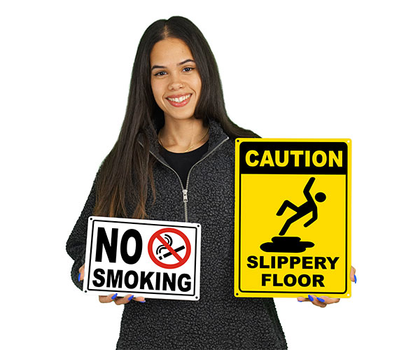 A woman holding two different facility signs